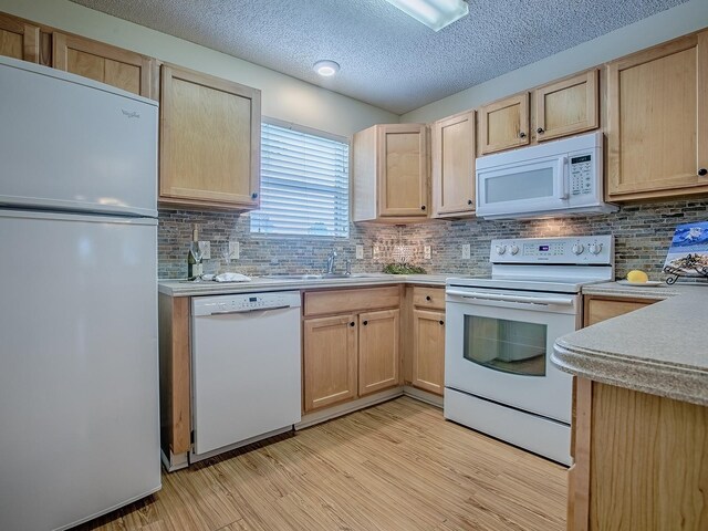 2799 Privada Dr, The Villages, FL 32162 - kitchen with white appliances, light brown cabinets, light wood-type flooring, and a textured ceiling