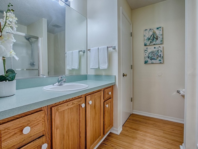2799 Privada Dr, The Villages, FL 32162 - full bath featuring vanity, wood finished floors, and a shower with shower door