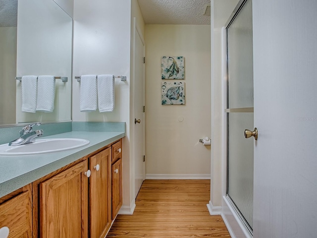 2799 Privada Dr, The Villages, FL 32162 - bathroom with wood finished floors, vanity, a stall shower, and a textured ceiling