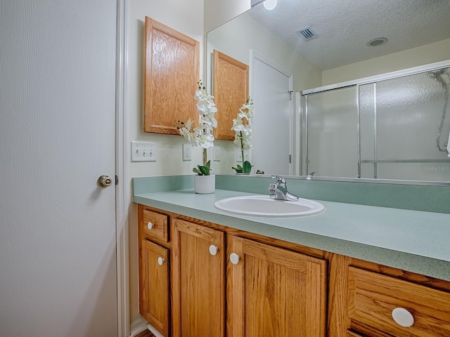 2799 Privada Dr, The Villages, FL 32162 - full bath featuring vanity, a shower with door, and a textured ceiling