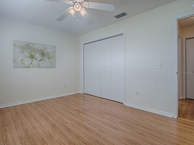 2799 Privada Dr, The Villages, FL 32162 - unfurnished bedroom featuring light wood-style floors, a closet, ceiling fan, and a textured ceiling