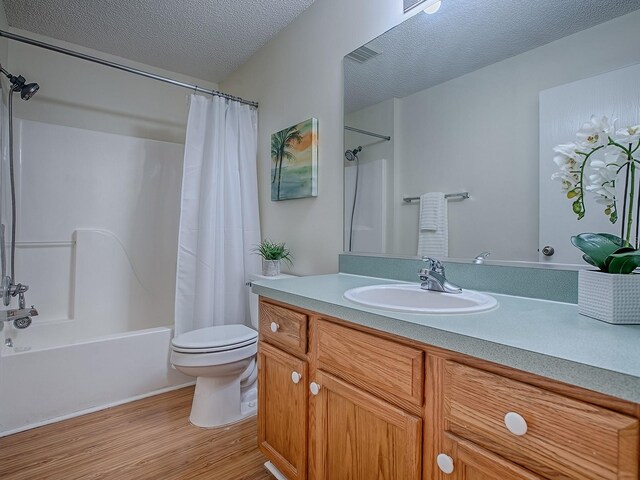 2799 Privada Dr, The Villages, FL 32162 - full bathroom with wood finished floors, vanity, shower / bath combo with shower curtain, and a textured ceiling