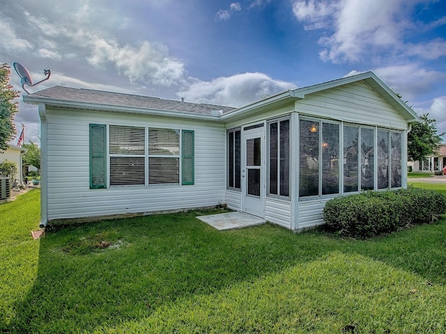 2799 Privada Dr, The Villages, FL 32162 - rear view of property featuring a sunroom, a yard, and a shingled roof