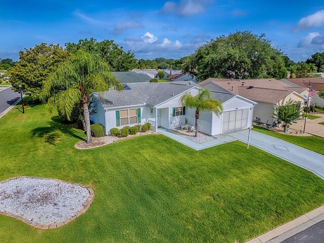 2799 Privada Dr, The Villages, FL 32162 - single story home featuring concrete driveway, a front lawn, an attached garage, and a residential view