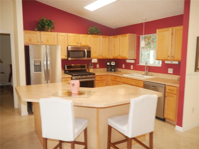 8377 SE 177th Bartram Loop, The Villages, FL 32162 - kitchen featuring stainless steel appliances, light brown cabinets, a sink, vaulted ceiling, and a breakfast bar area