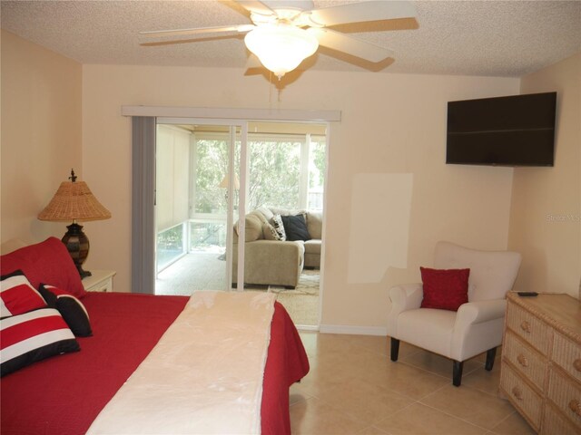 8377 SE 177th Bartram Loop, The Villages, FL 32162 - bedroom with access to exterior, a textured ceiling, ceiling fan, and light tile patterned flooring