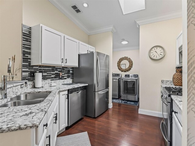 17324 SE 82nd Pecan Ter, The Villages, FL 32162 - kitchen featuring washing machine and dryer, stainless steel appliances, crown molding, decorative backsplash, and light stone countertops