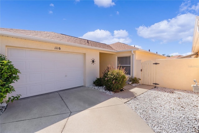 1116 San Bernardo Rd, The Villages, FL 32162 - ranch-style home with stucco siding, a gate, driveway, and an attached garage