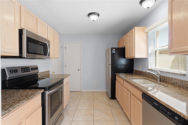 1116 San Bernardo Rd, The Villages, FL 32162 - kitchen with stainless steel appliances, light brown cabinets, a sink, a textured ceiling, and light tile patterned floors