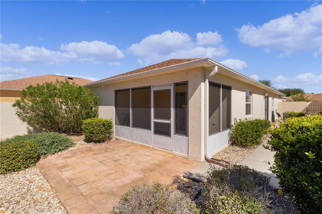 1116 San Bernardo Rd, The Villages, FL 32162 - rear view of house with stucco siding, a patio, and a sunroom