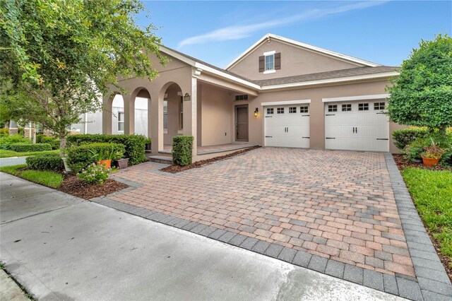 15531 Waterleigh Cove Dr, Winter Garden, FL 34787 - traditional home with stucco siding, decorative driveway, and an attached garage