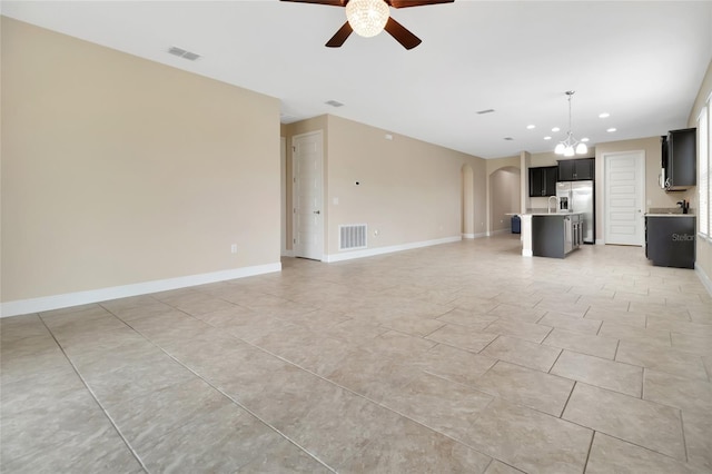 15531 Waterleigh Cove Dr, Winter Garden, FL 34787 - unfurnished living room with a ceiling fan, arched walkways, a chandelier, recessed lighting, and light tile patterned floors
