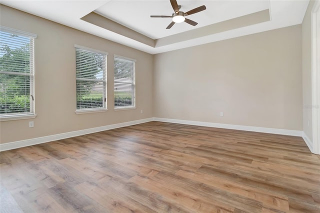 15531 Waterleigh Cove Dr, Winter Garden, FL 34787 - spare room with a tray ceiling, a ceiling fan, and light wood-style floors