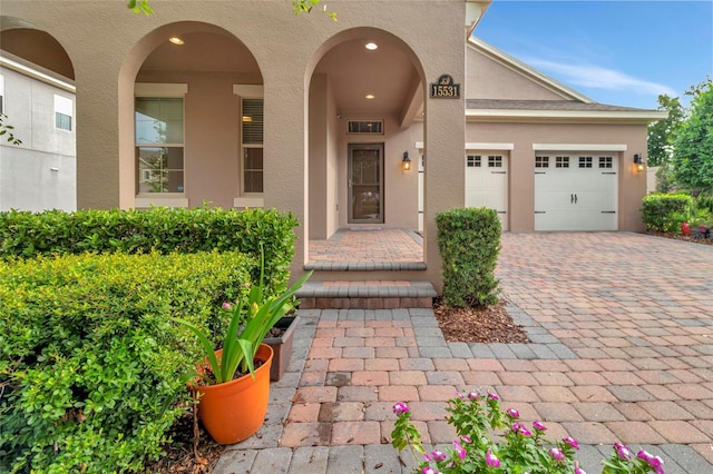 15531 Waterleigh Cove Dr, Winter Garden, FL 34787 - property entrance featuring stucco siding, decorative driveway, and an attached garage