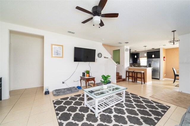 212 Primrose Dr, Davenport, FL 33837 - living area featuring light tile patterned floors, ceiling fan, stairs, and baseboards