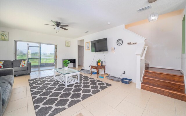 212 Primrose Dr, Davenport, FL 33837 - tiled living room with ceiling fan, stairs, and baseboards