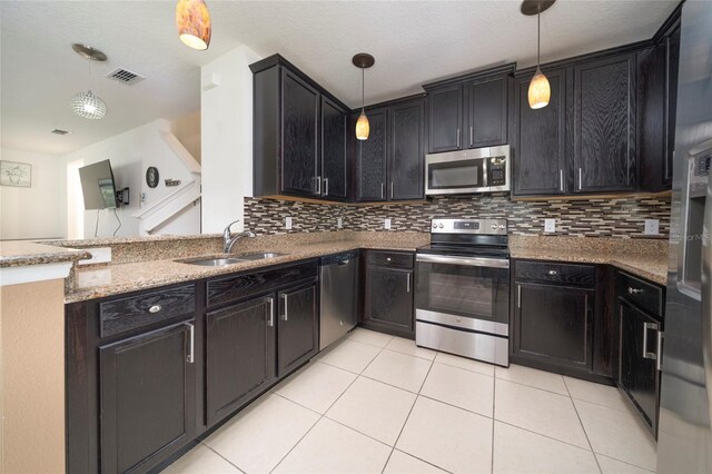212 Primrose Dr, Davenport, FL 33837 - kitchen with appliances with stainless steel finishes, a sink, light tile patterned floors, and light stone counters
