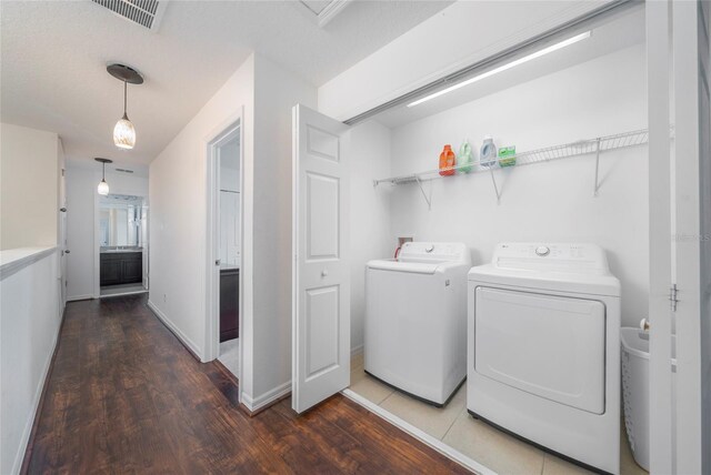 212 Primrose Dr, Davenport, FL 33837 - laundry area featuring wood finished floors, washing machine and clothes dryer, and baseboards