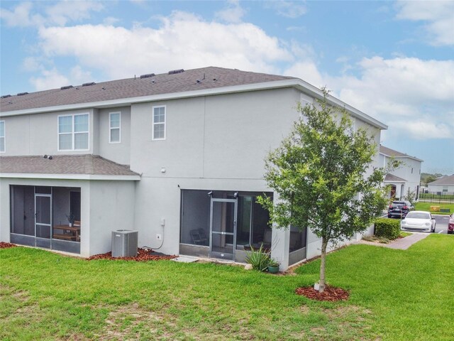 212 Primrose Dr, Davenport, FL 33837 - back of house featuring a sunroom, a lawn, and central air condition unit