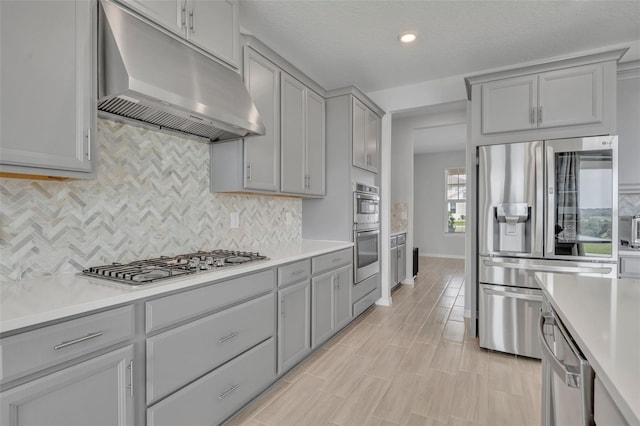 2147 Timber Creek Ln, Clermont, FL 34715 - kitchen featuring under cabinet range hood, stainless steel appliances, gray cabinetry, light countertops, and decorative backsplash