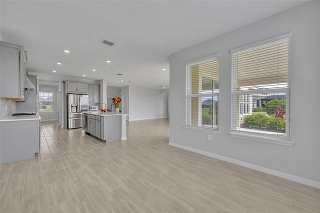 2147 Timber Creek Ln, Clermont, FL 34715 - kitchen featuring stainless steel refrigerator with ice dispenser, open floor plan, gray cabinetry, light countertops, and baseboards