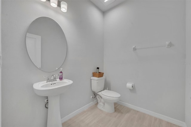 2147 Timber Creek Ln, Clermont, FL 34715 - half bath with baseboards, toilet, wood finished floors, and a sink