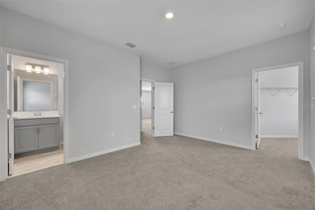 2147 Timber Creek Ln, Clermont, FL 34715 - unfurnished bedroom featuring light carpet, a sink, a walk in closet, baseboards, and recessed lighting