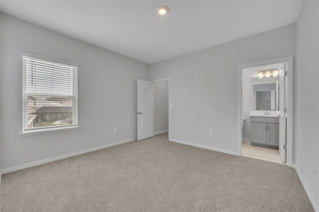 2147 Timber Creek Ln, Clermont, FL 34715 - unfurnished bedroom featuring light colored carpet, baseboards, ensuite bath, and a sink