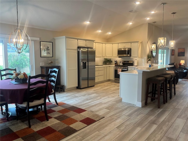 3466 Smedley Rd, The Villages, FL 32163 - kitchen with stainless steel appliances, a chandelier, a peninsula, light wood finished floors, and light countertops