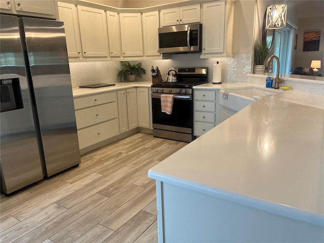 3466 Smedley Rd, The Villages, FL 32163 - kitchen with stainless steel appliances, light wood-style floors, light countertops, and backsplash