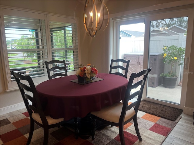 3466 Smedley Rd, The Villages, FL 32163 - dining area featuring healthy amount of natural light, a chandelier, baseboards, and light wood-style floors