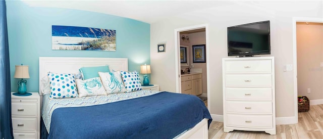 3466 Smedley Rd, The Villages, FL 32163 - bedroom featuring light wood-type flooring, baseboards, connected bathroom, and a sink