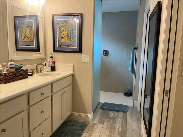 3466 Smedley Rd, The Villages, FL 32163 - bathroom with double vanity, wood finished floors, a walk in shower, and baseboards