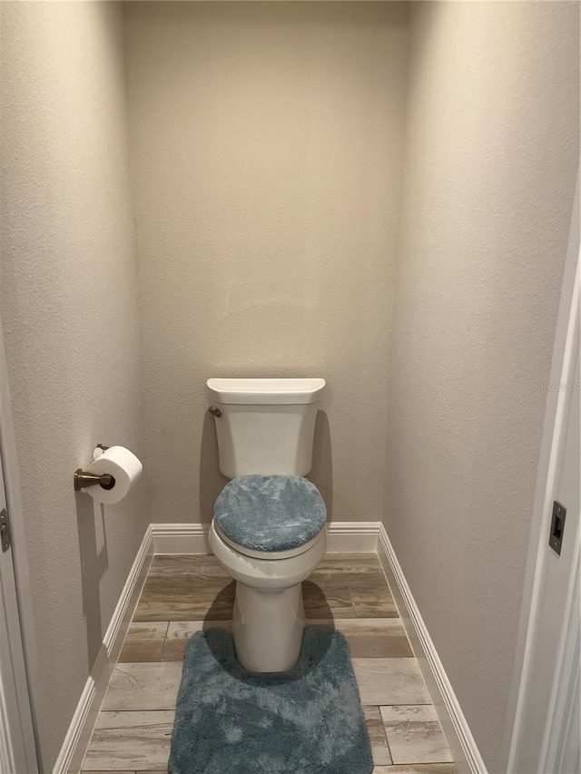 3466 Smedley Rd, The Villages, FL 32163 - bathroom featuring toilet, wood finished floors, and baseboards