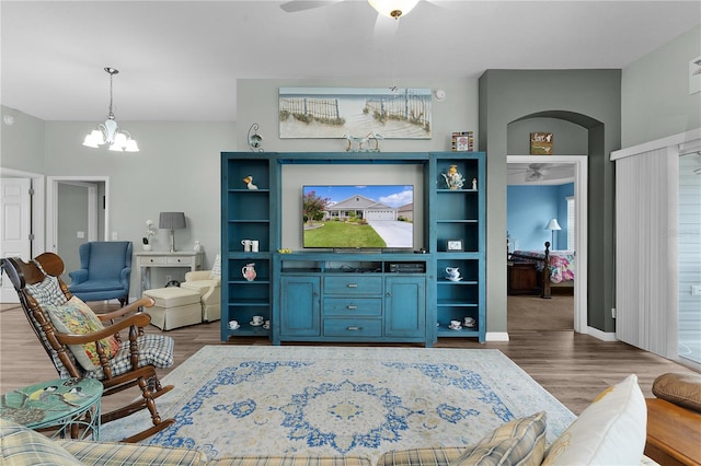 3978 Nottingham Loop, The Villages, FL 32163 - living room with wood finished floors, ceiling fan, a chandelier, arched walkways, and baseboards