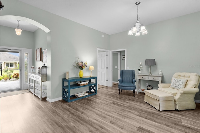 3978 Nottingham Loop, The Villages, FL 32163 - living area featuring light wood finished floors, a chandelier, arched walkways, baseboards, and a high ceiling