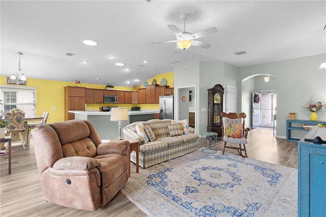 3978 Nottingham Loop, The Villages, FL 32163 - living room featuring arched walkways, light wood-style floors, lofted ceiling, a ceiling fan, and a chandelier