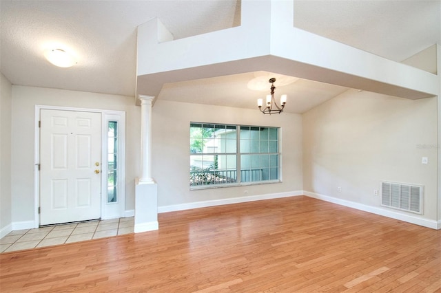 832 Willow Run St, Minneola, FL 34715 - foyer featuring ornate columns, light wood-type flooring, and a chandelier