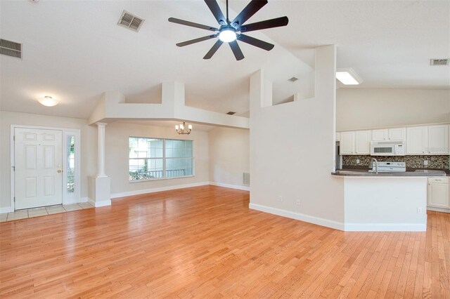 832 Willow Run St, Minneola, FL 34715 - unfurnished living room featuring light wood-style floors, a chandelier, ceiling fan, high vaulted ceiling, and decorative columns