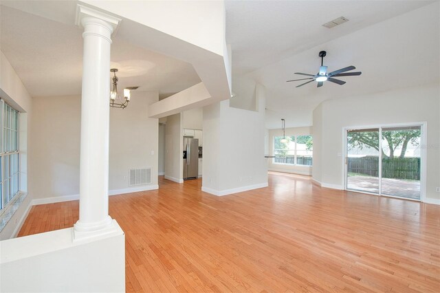 832 Willow Run St, Minneola, FL 34715 - unfurnished living room with ornate columns, light wood-style floors, a ceiling fan, high vaulted ceiling, and a chandelier