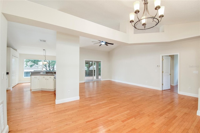 832 Willow Run St, Minneola, FL 34715 - unfurnished living room featuring a chandelier, light wood finished floors, and healthy amount of natural light
