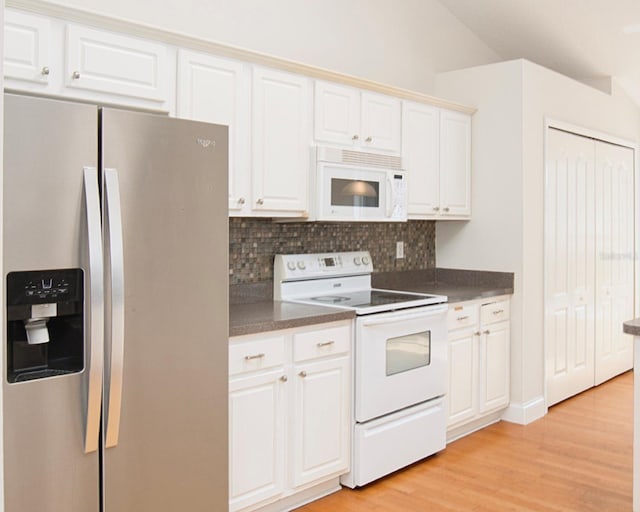 832 Willow Run St, Minneola, FL 34715 - kitchen with white appliances, dark countertops, backsplash, and light wood-style flooring