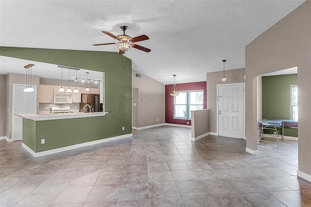 15916 Indian Wells Ct, Clermont, FL 34711 - unfurnished living room featuring ceiling fan, lofted ceiling, a textured ceiling, and baseboards