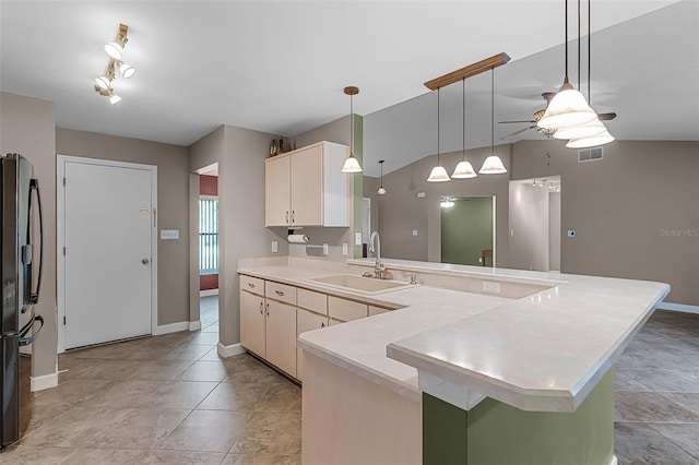 15916 Indian Wells Ct, Clermont, FL 34711 - kitchen with a sink, black fridge, light countertops, a peninsula, and pendant lighting
