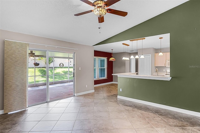 15916 Indian Wells Ct, Clermont, FL 34711 - unfurnished living room with vaulted ceiling, ceiling fan, light tile patterned floors, a sink, and baseboards