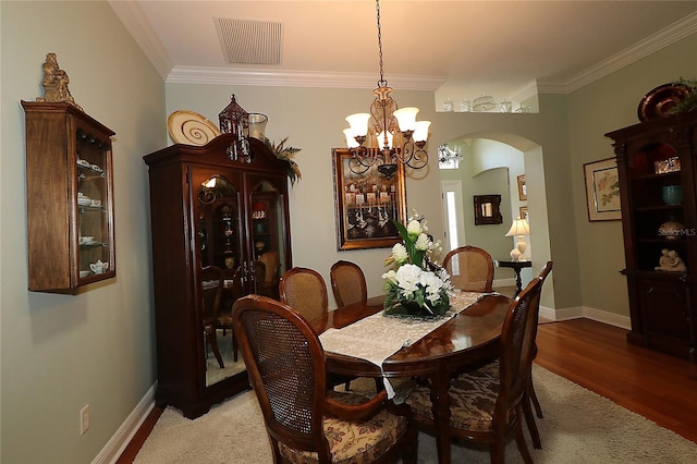 1553 Lynchburg Loop, The Villages, FL 32162 - dining area with arched walkways, a chandelier, crown molding, baseboards, and wood finished floors