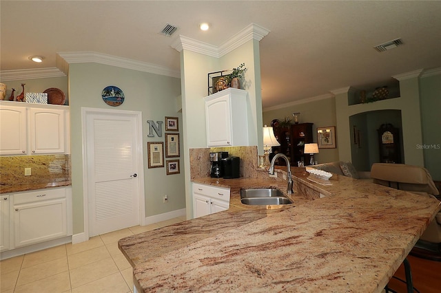 1553 Lynchburg Loop, The Villages, FL 32162 - kitchen with a sink, a peninsula, decorative backsplash, a breakfast bar, and light stone counters