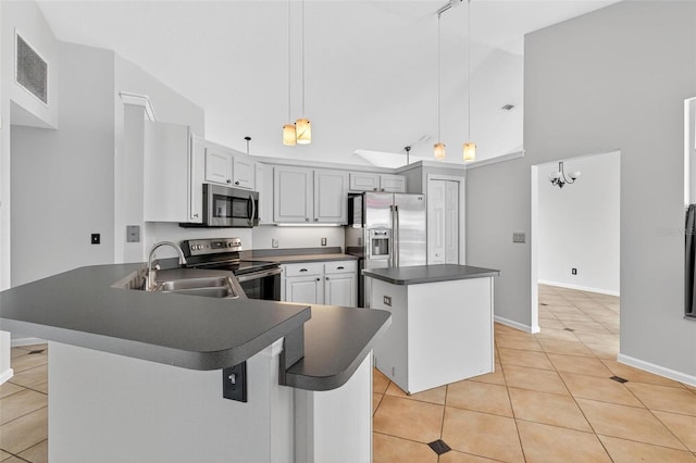 2705 Bayview Dr, Eustis, FL 32726 - kitchen with stainless steel appliances, a towering ceiling, dark countertops, a kitchen island, and light tile patterned flooring