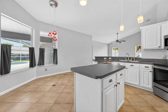 2705 Bayview Dr, Eustis, FL 32726 - kitchen with a sink, stainless steel appliances, dark countertops, light tile patterned flooring, and decorative light fixtures