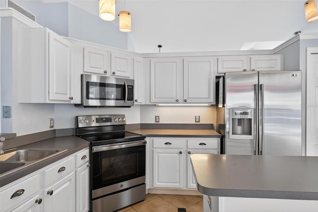 2705 Bayview Dr, Eustis, FL 32726 - kitchen featuring appliances with stainless steel finishes, light tile patterned flooring, white cabinets, dark countertops, and a sink